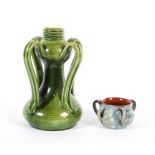 A Continental Arts and Crafts green glazed vase and a C.H. Brannam pottery three-handled salt,