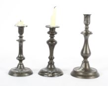 A pair of Dutch style pewter candlesticks, with a broad drip pan and domed foot,