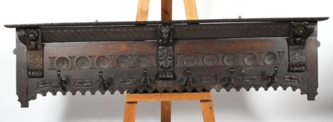 A carved stained oak coat stand, 19th century, carved with lions bracket supports,