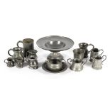 A collection of pewter tankards and measures of various shapes,