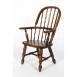 A child's elm Windsor chair, on turned baluster splayed legs,