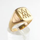 A yellow metal oval signet ring with inscription.