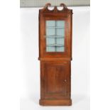 A Georgian oak two-part corner cupboard, with broken swan's neck pediment,