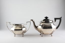 A George V silver teapot of octagonal form, raised upon four feet,