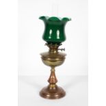 An Edwardian brass oil lamp,with opaque green fluted glass shade above a brass burner and reservoir,