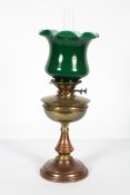 An Edwardian brass oil lamp,with opaque green fluted glass shade above a brass burner and reservoir,