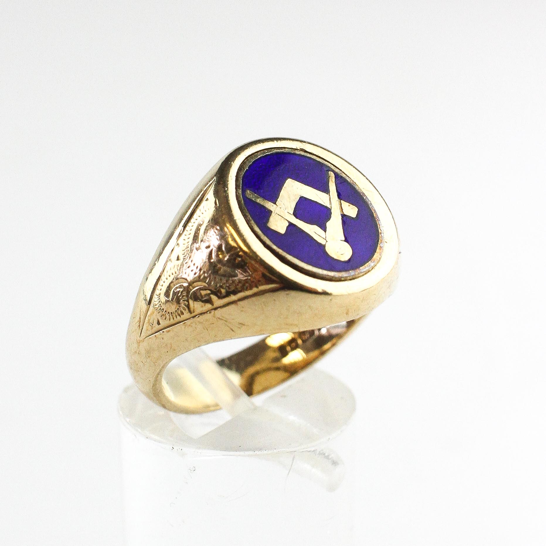 A yellow metal oval signet ring having a hinged reversible centre section