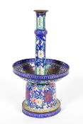 A Chinese enamel pricket candlestick with large drip pan above a bell shaped base,
