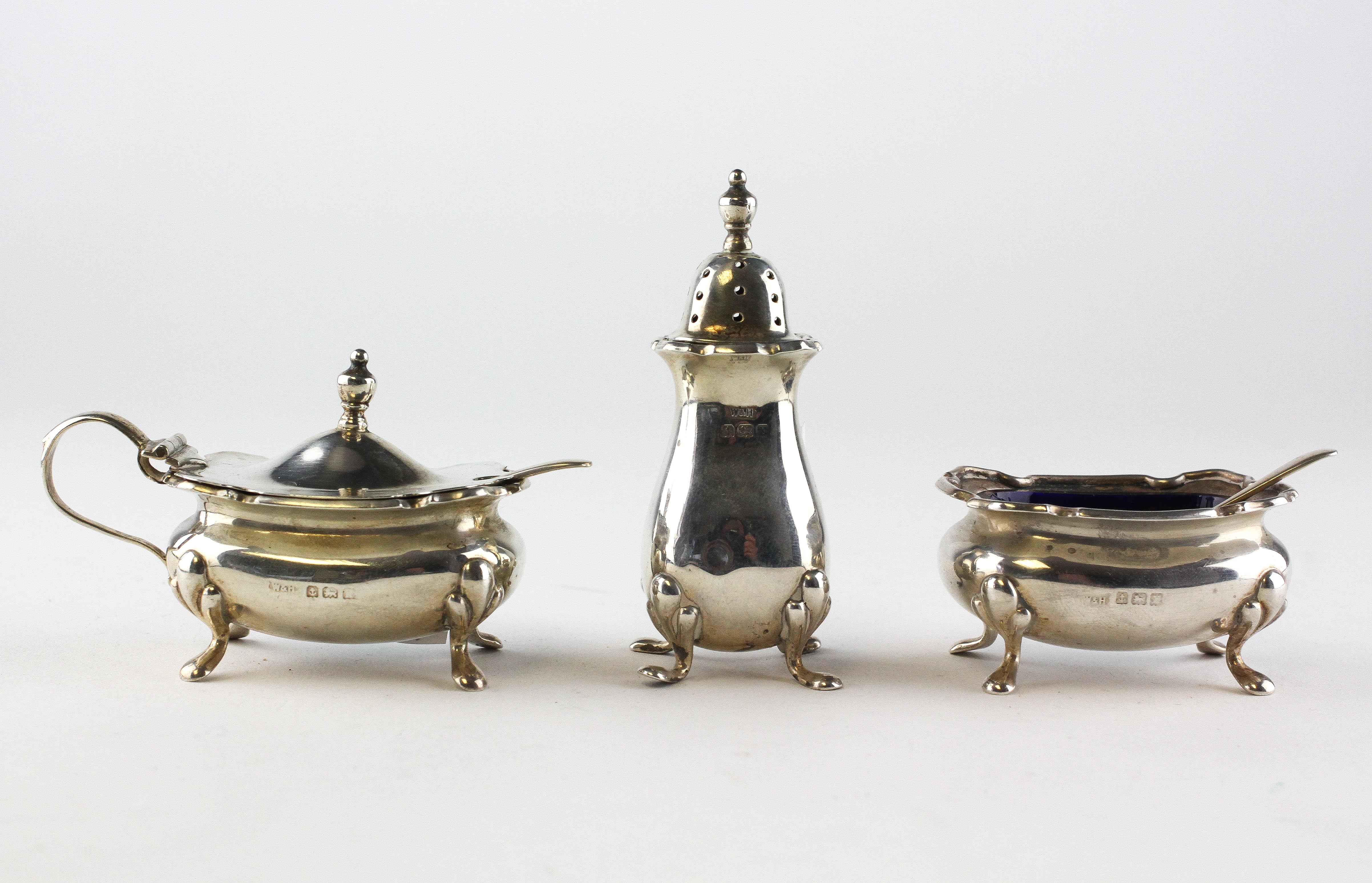 A three piece silver cruet set, comprising lidded mustard, open salt and a pepper pot,