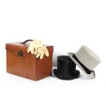 A vintage leather hat case with two top hats, including a Moss Bros. grey top hat (20 cm.