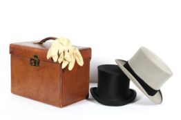 A vintage leather hat case with two top hats, including a Moss Bros. grey top hat (20 cm.