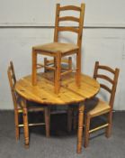 A set of four pine dining chairs (96cm high) together with a round pine table (75cm high x106cm