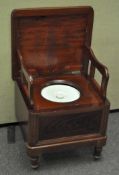 A Victorian mahogany chamber pot, opening to reveal supports and original ceramic pot,