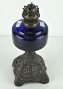 An early 20th century Welco metal oil lamp base with blue glass reservoir,