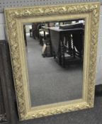 A large modern wall mirror of rectangular form and gilt detailing, with bevelled edge,