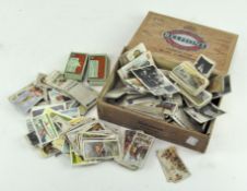 A cigar box containing a large number of loose cigarette cards