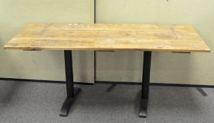 A vintage wooden door adapted into a table top, mounted two metal legs,