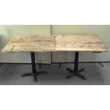 Two breakfast tables made from a tongue and groove door, on iron bases,