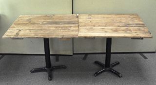 Two breakfast tables made from a tongue and groove door, on iron bases,