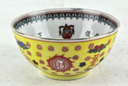 A Chinese porcelain rice bowl, decorated on a yellow ground,