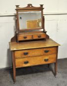 A 20th century oak dressing table with mirror, raised upon tapering supports,