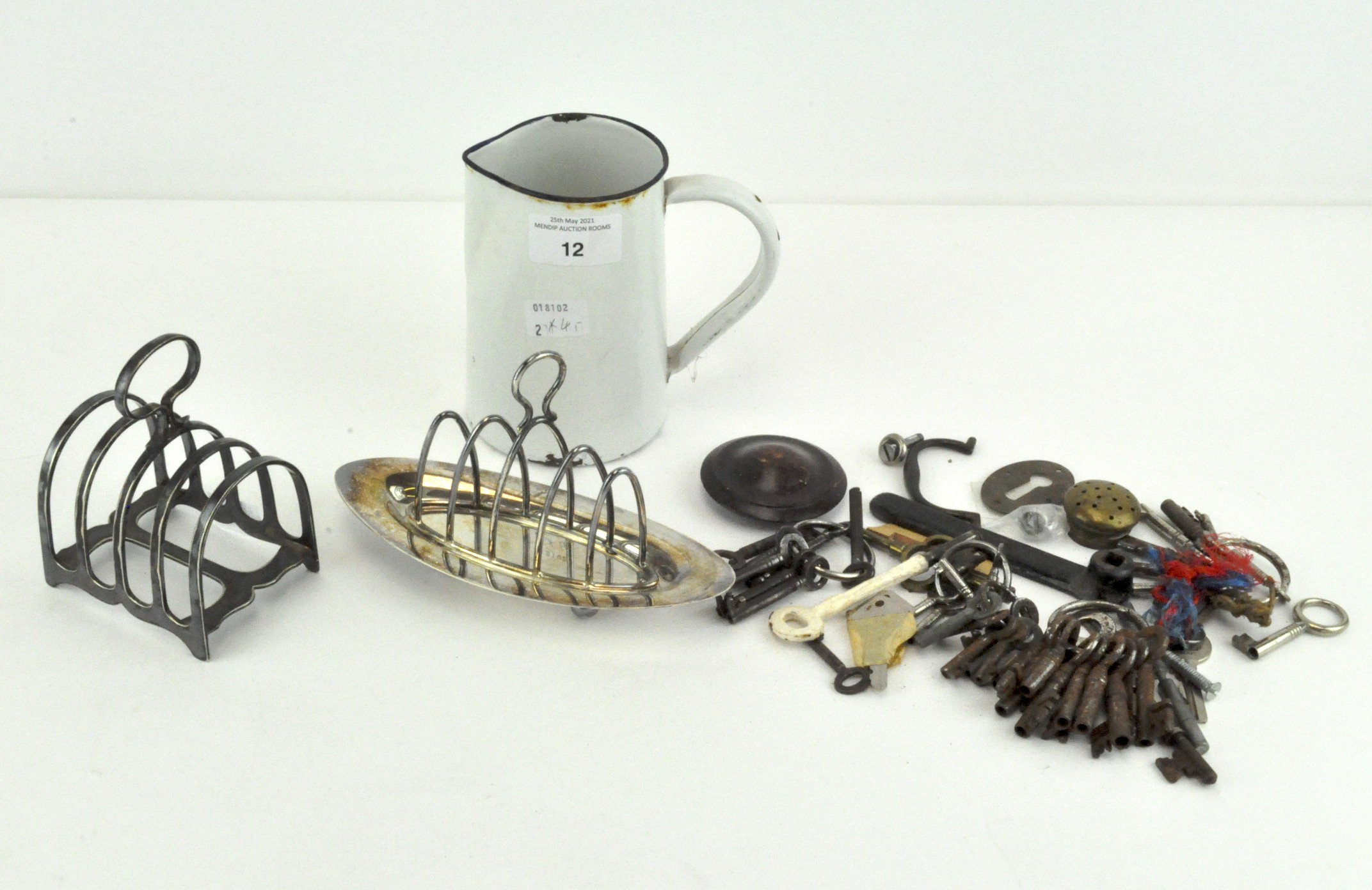 Two silver plated toast racks, an enamelled jug,