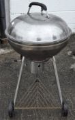 A stainless steel circular barbecue,