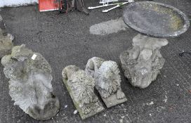 A group of four reconstituted stone figures including a pair of lions and bird bath