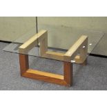 A modern glass topped coffee table of square form,,