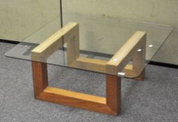 A modern glass topped coffee table of square form,,