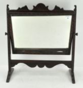 An oak dressing table swing mirror with carved borders,