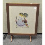 An early 20th century framed tapestry fire screen depicting a lady in formal dress,