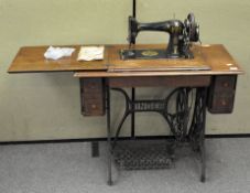 An early 20th century Singer sewing machine wooden stand with treddle,