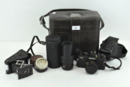 An Edwardian Eastman Kodak folding camera, a light meter and a Mamiya ZE slr camera with two lenses