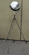A large industrial floor standing show spot light, on tripod stand,