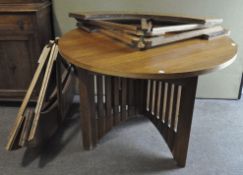 An oak circular dining table, 20th century, on four legs with vertical slatted supports,