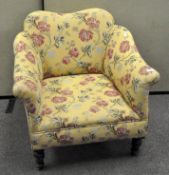 A floral armchair, raised on wooden supports,