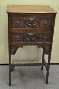 A mahogany two drawer cupboard, carved decoration to the front,
