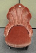 A 19th century upholstered nursing chair, the back of shell form.