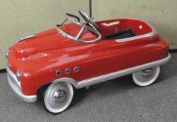 A vintage child's pedal car in the form of a classic American car