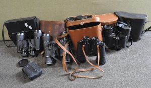 A collection of vintage field binoculars, including Pacific 10 x 50, Garton Prisma,