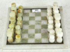 A vintage stone chess set with matching board,