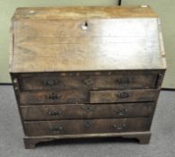 A Queen Anne burr wood veneered bureau, the drop front opening to reveal fitted interior,