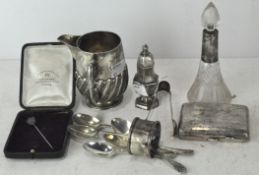 A collection of silver items, including a scent bottle, cigarette case, sugar tongs,