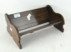 An oak book slide in the form of a bench, decorated with beaded edge,