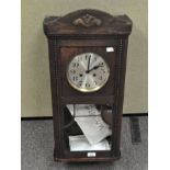 A 20th century oak cased wall clock, with pendulum,