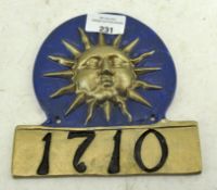 A painted metal fire insurance plaque in the form of a sun, numbered 1710,