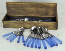 A vintage oak cutlery box containing a selection of modern cutlery