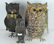 A group of three metal figures of owls, one as a solar light,