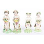 Four Samson 18th century Chelsea-Derby style figures, on mound bases, holding baskets of flowers,
